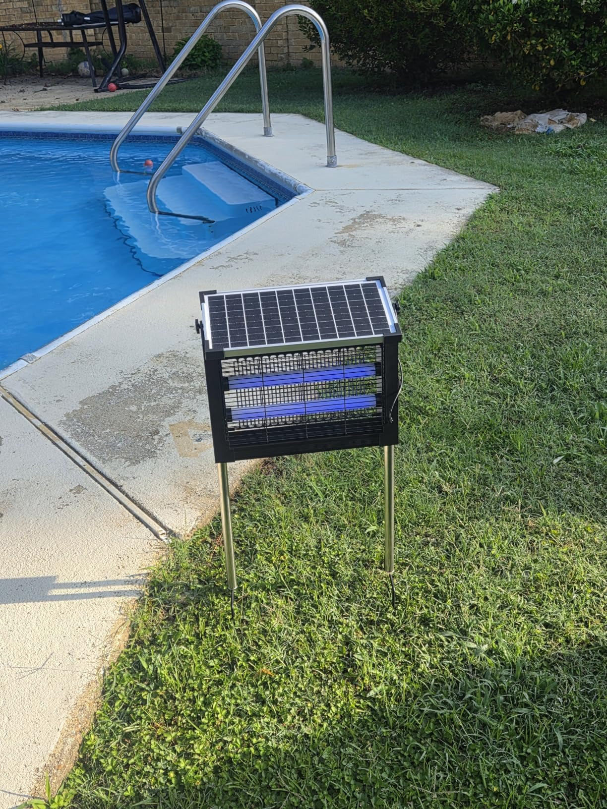 Bug zapper on a poolside table at dusk
